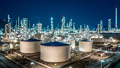 Oil refinery plant from industry zone, Aerial view oil and gas industrial, Refinery factory oil storage tank and pipeline steel at night.