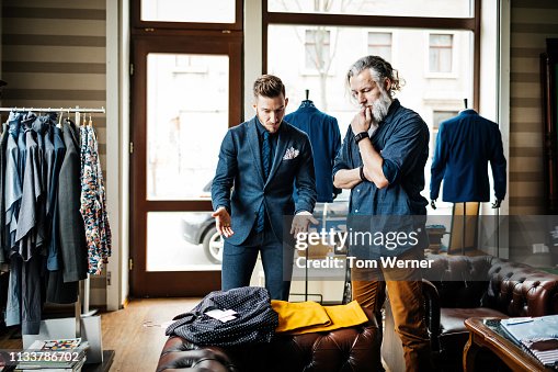 Retail Assistant Advising Customer Shopping For Clothes Retail Assistant Advising Customer Shopping For Clothes