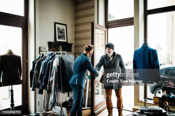 mature man shaking hands with store owner - black men shaking stock pictures, royalty-free photos & images