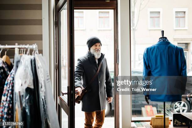 mature man entering clothing store - entering shop stock pictures, royalty-free photos & images