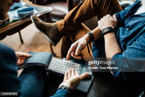 retail assistant and customer looking at fabric swatches - fabric swatches imagens e fotografias de stock