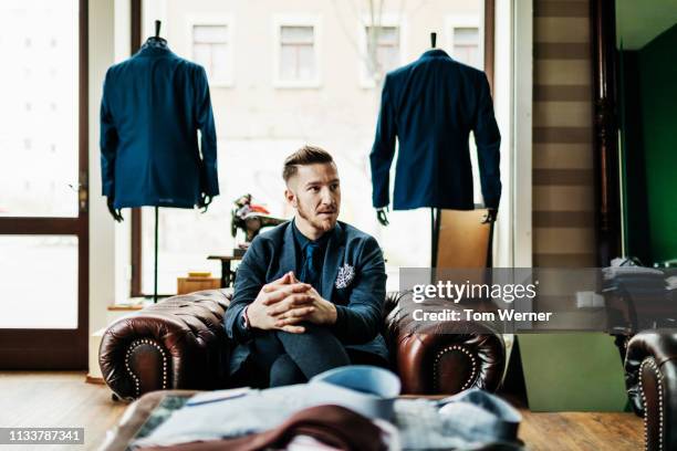 menswear store owner sitting down in leather chair - tailor made ストックフォトと画像