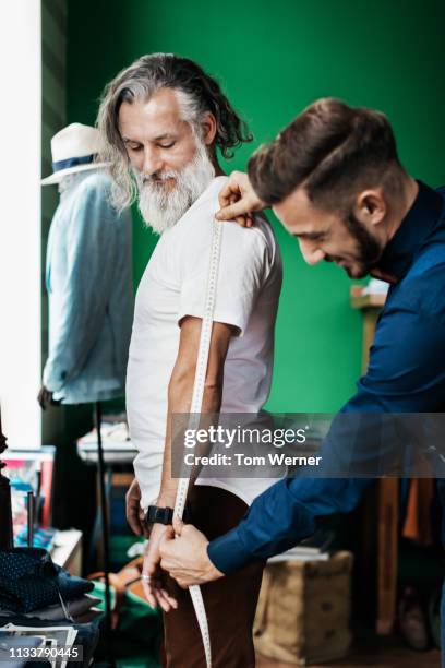 tailor measuring customers arms - merchant navy stock pictures, royalty-free photos & images