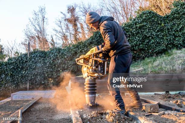 man using rammer tamper (jumping jack) for soil compacting - boom for real stock pictures, royalty-free photos & images