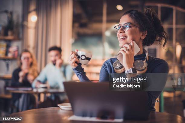 mooie jonge vrouwelijke koffie drinken in de bibliotheek. - male student wearing glasses with friends stockfoto's en -beelden