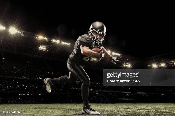 american football sportsman player on stadium running in action. sport wallpaper with copyspace. - touchdown quarterback stock pictures, royalty-free photos & images