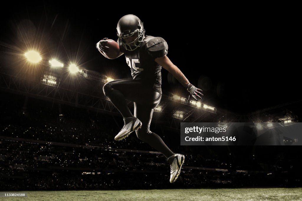 American football sportsman player on stadium running in action. Sport wallpaper with copyspace.