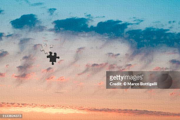 sunset clouds jigsaw puzzle with one missing piece - jigsaw piece ストックフォトと画像