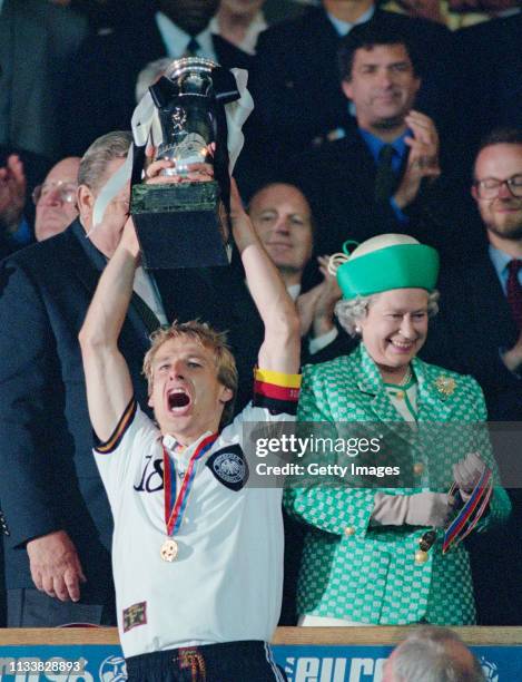 Germany captain Jurgen Klinsmann lifts the trophy as Her Majesty Queen Elizabeth II smiles after the 1996 UEFA European Championships Final against...