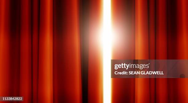 red stage curtains with light shining through - theatre awards stock pictures, royalty-free photos & images