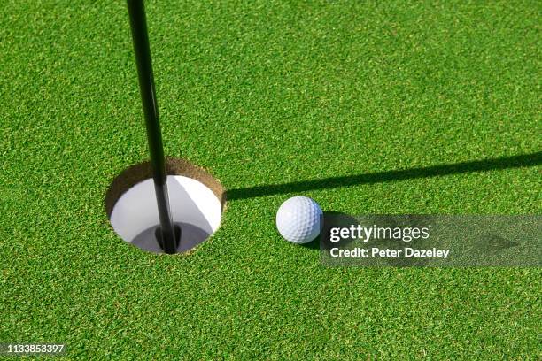 golf ball on green - golf putting stock pictures, royalty-free photos & images