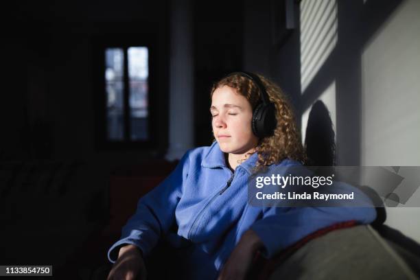 young woman listening music with headphones - podcast headphones stock pictures, royalty-free photos & images