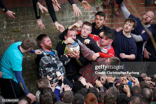 Rival teams the 'Up'ards and Down'ards' battle for the ball during the annual Ashbourne Royal Shrovetide 'no rules' football match on March 05, 2019...