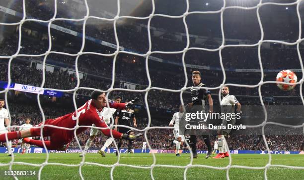 Thibaut Courtois of Real Madrid fails to stop Hakim Ziyech of Ajax from scoring his team's first goal during the UEFA Champions League Round of 16...