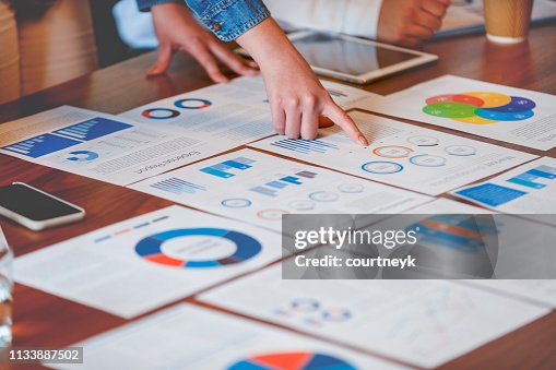 Paperwork and hands on a board room table at a business presentation or seminar. Paperwork and hands on a board room table at a business presentation or seminar.