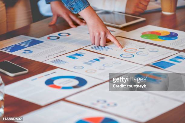 paperwork and hands on a board room table at a business presentation or seminar. - data stock pictures, royalty-free photos & images