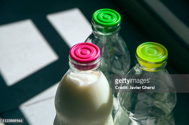 botellas de vidrio con leche y vacías - estilo de vida saludable stock-fotos und bilder