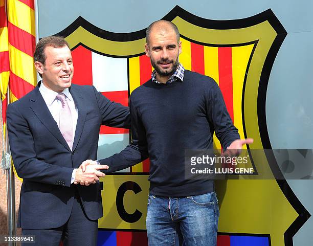 Barcelona's coach Josep Guardiola shakes hands with Barcelona's Sandro Rosell on February 23, 2011 at Camp Nou stadium in Barcelona after signing his...