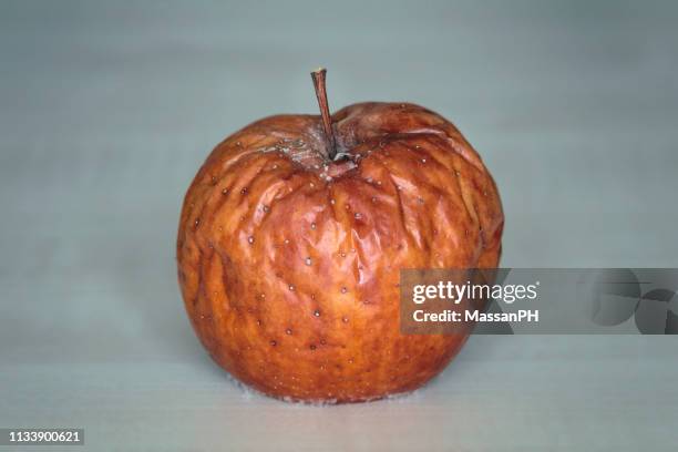 rotting apple with wrinkles and mould - dry rot stock pictures, royalty-free photos & images