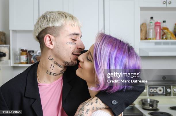 joven tatuado pareja posando en su cocina - bleached hair fotografías e imágenes de stock