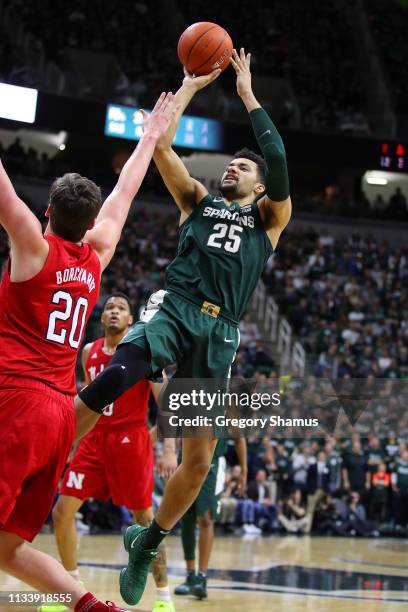 Kenny Goins of the Michigan State Spartans takes a first half shot over Tanner Borchardt of the Nebraska Cornhuskers at Breslin Center on March 05,...