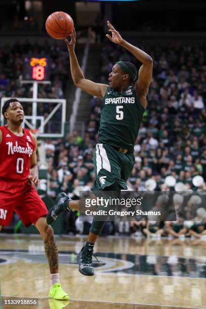 Cassius Winston of the Michigan State Spartans looks to pass in front of James Palmer Jr. #0 of the Nebraska Cornhuskers at Breslin Center on March...