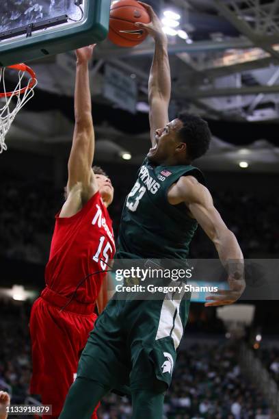 Xavier Tillman of the Michigan State Spartans tries to dunk over Isaiah Roby of the Nebraska Cornhuskers during the first half at Breslin Center on...