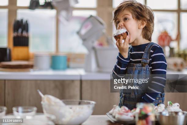 little boy verkostung geburtstagsmuffins - cream mouth stock-fotos und bilder