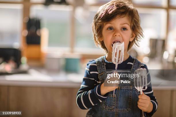 cute kid tasting whipped cream of egg beater - electric mixer stock pictures, royalty-free photos & images