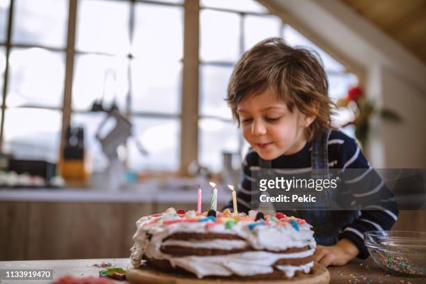making a wish on his birthday - birthday cake stock pictures, royalty-free photos & images