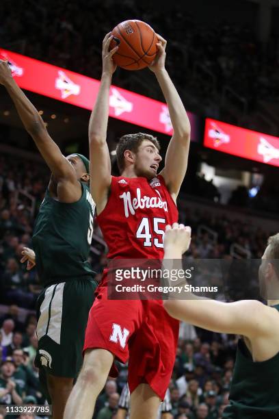 Brady Heiman of the Nebraska Cornhuskers grabs a rebound in front of Cassius Winston of the Michigan State Spartans during the second half at Breslin...