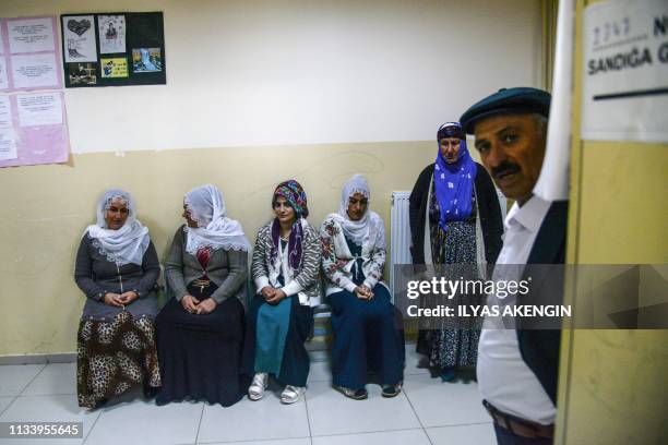 People wait at a polling station in the southeastern Turkey Kurdish stronghold of Diyarbakir on March 31, 2019 during the local elections to elect...