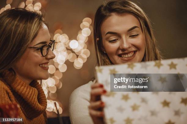 christmas gift from a loving sister - giving a girl head stock pictures, royalty-free photos & images