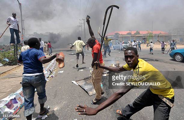 People holding wooden and metal sticks demonstrate in Nigeria's northern city of Kano where running battles broke out between protesters and soldiers...