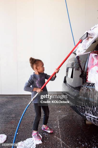 little girl washing a car - car wash brush fotografías e imágenes de stock