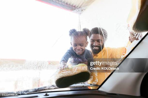 father and daughter washing their car - car splashing water on people stock pictures, royalty-free photos & images