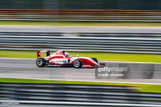 man driving formula racing car - car racing blurred motion stock pictures, royalty-free photos & images