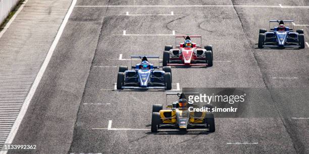men driving formula racing cars - four people in car stock pictures, royalty-free photos & images