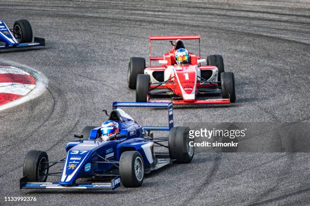 men driving formula racing cars - athletics grand prix stock pictures, royalty-free photos & images