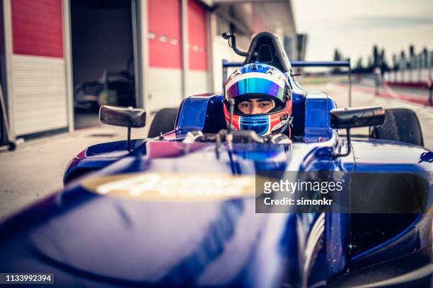 hombre conduciendo fórmula coche de carreras - piloto de coches de carrera fotografías e imágenes de stock