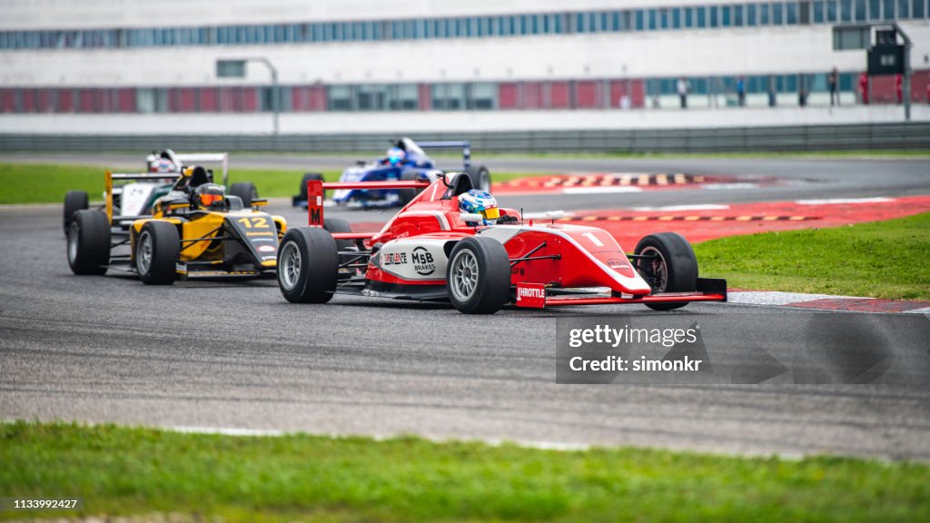Hommes conduisant des voitures de course de formule