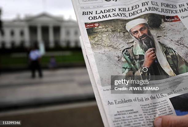 Man takes pictures of the front page of a newspaper featuring a picture of Al-Qaeda leader Osama bin Laden, in front of the White House in...