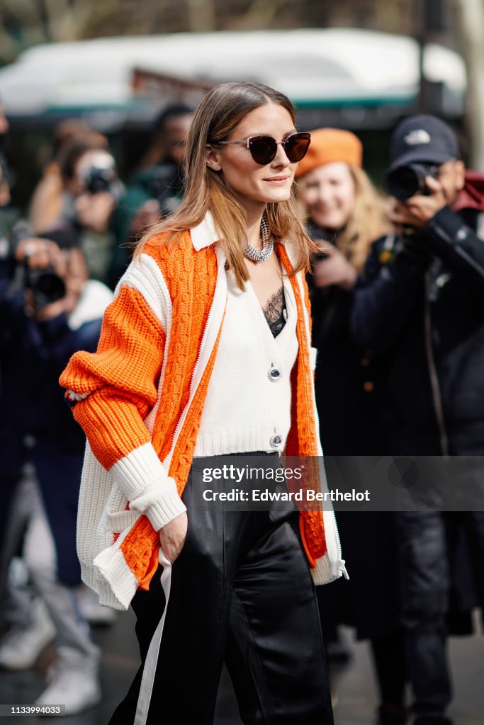 Olivia Palermo wears an orange wool knitted jacket, black flared ...
