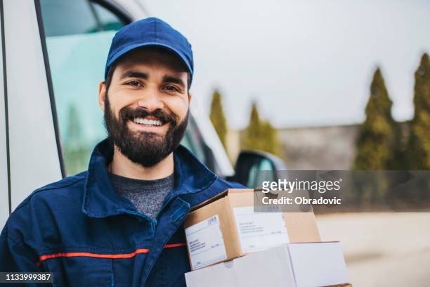 portrait of a smiling deliverer - messenger stock pictures, royalty-free photos & images