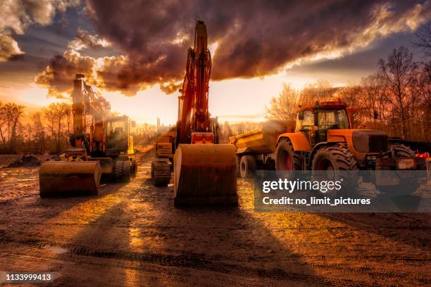 bagger und ein lkw auf baustelle - hebebühne stock-fotos und bilder