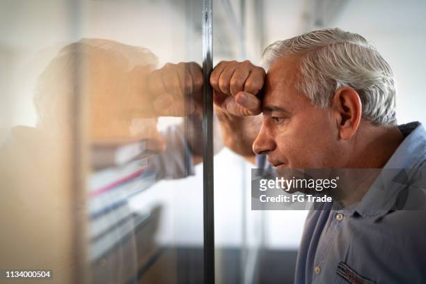 inquiet homme d'affaires aîné se sentant stressé au travail - distraught photos et images de collection