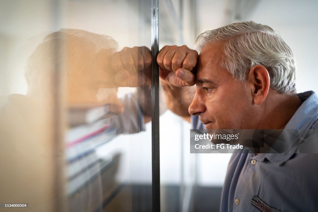 Worried senior businessman feeling stressed at work