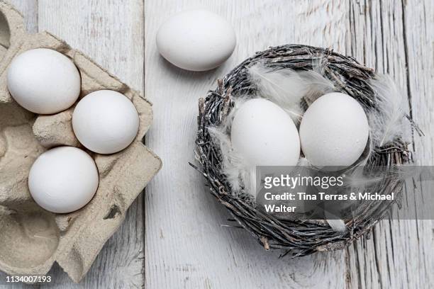 egg in nest on dark wooden background. easter. - osterkorb stockfoto's en -beelden