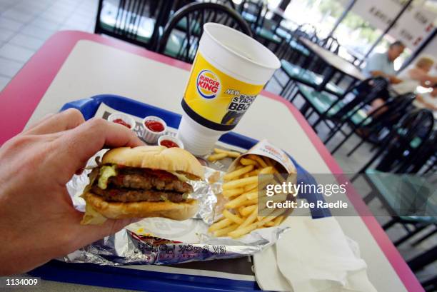 Double hamburger with a King Fries and a King size Coke is seen on July 18, 2002 at a Burger King in Miami, Florida. The health effects of an...