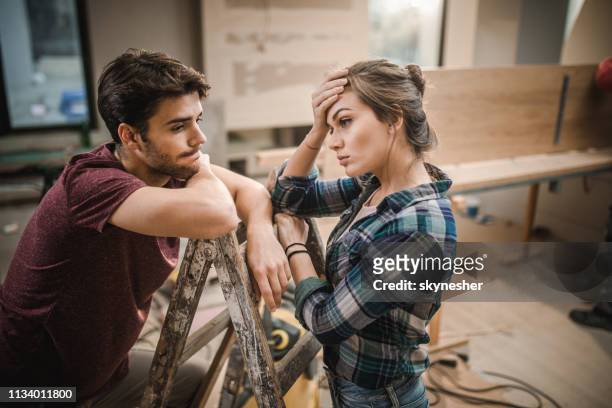 young couple having problems while renovating their apartment. - couple relationship difficulties stock pictures, royalty-free photos & images